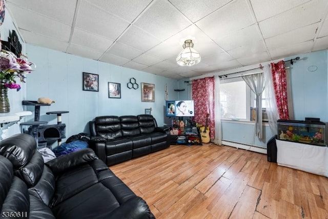 159 2nd St, Elizabeth City, NJ 07206 - living area with a baseboard heating unit, a paneled ceiling, hardwood / wood-style flooring, and a chandelier