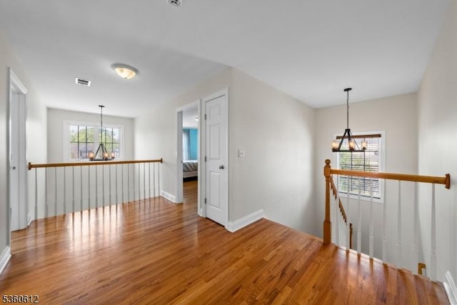 143 Oak St, Bridgewater Twp, NJ 08807 - empty room with a chandelier, wood finished floors, and baseboards