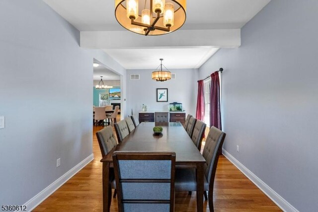 143 Oak St, Bridgewater Twp, NJ 08807 - dining room with a chandelier, wood finished floors, baseboards, healthy amount of natural light, and beamed ceiling