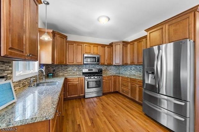 143 Oak St, Bridgewater Twp, NJ 08807 - kitchen featuring appliances with stainless steel finishes, a sink, brown cabinets, and light wood-style floors