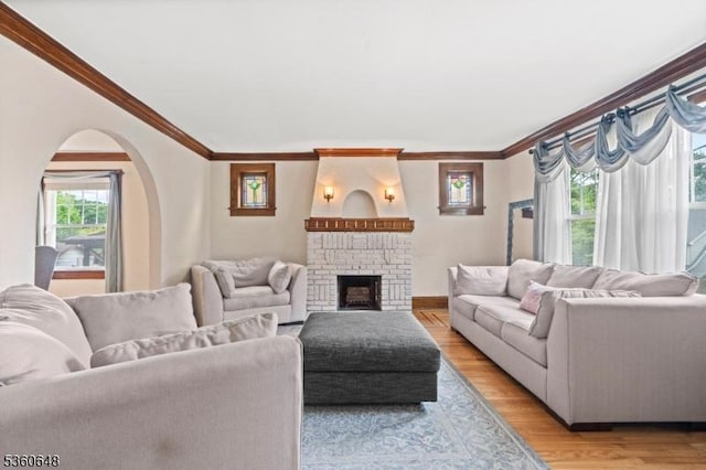126 Beech St, Nutley Twp, NJ 07110 - living room with ornamental molding, arched walkways, a fireplace, light wood-style floors, and baseboards
