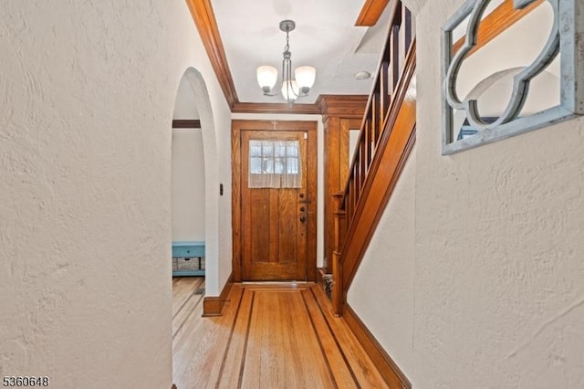 126 Beech St, Nutley Twp, NJ 07110 - doorway featuring a textured wall, arched walkways, ornamental molding, a chandelier, and light wood-type flooring