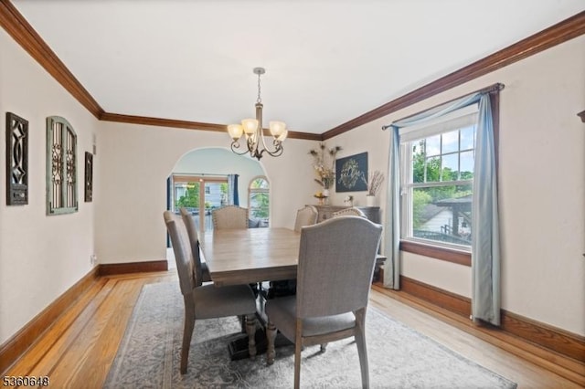 126 Beech St, Nutley Twp, NJ 07110 - dining space featuring plenty of natural light, light wood finished floors, a chandelier, crown molding, and arched walkways