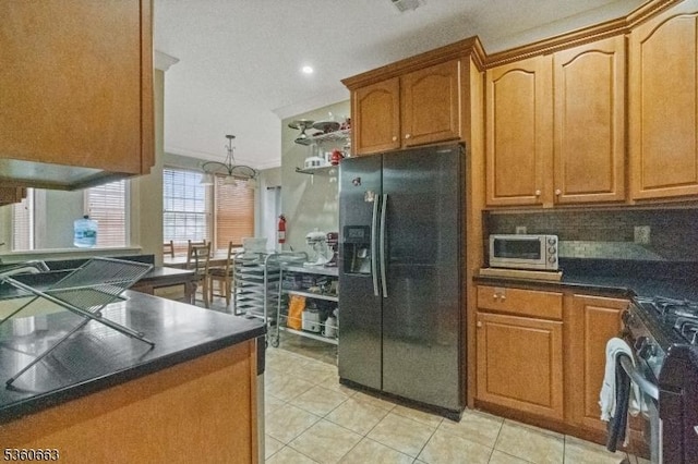 40 Upsala Ct, East Orange City, NJ 07017 - kitchen with black fridge, gas stove, light tile patterned floors, dark countertops, and crown molding