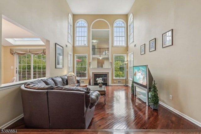 9 Labaw Way, Montgomery Twp, NJ 08502 - living room with a towering ceiling, wood-type flooring, baseboards, a glass covered fireplace, and a skylight