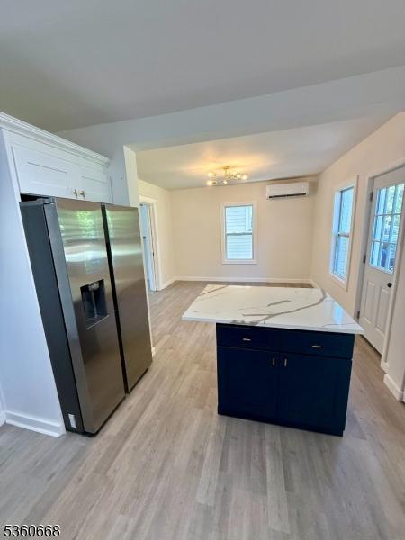 67 Mead St, Newark City, NJ 07106 - kitchen with stainless steel fridge with ice dispenser, a wall unit AC, light wood-style flooring, and baseboards