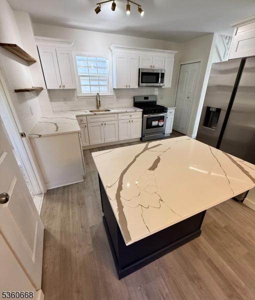67 Mead St, Newark City, NJ 07106 - kitchen featuring stainless steel appliances, open shelves, white cabinets, wood finished floors, and light stone counters