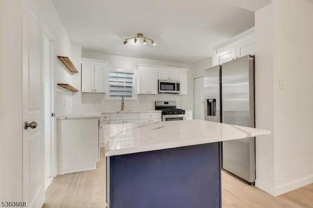 67 Mead St, Newark City, NJ 07106 - kitchen with stainless steel appliances, open shelves, light wood-style floors, white cabinetry, and a kitchen island