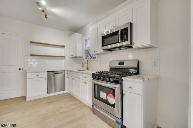 67 Mead St, Newark City, NJ 07106 - kitchen with appliances with stainless steel finishes, open shelves, a sink, backsplash, and white cabinets