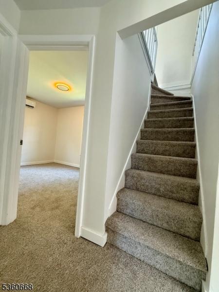 67 Mead St, Newark City, NJ 07106 - stairway featuring carpet floors, baseboards, and a wall mounted air conditioner