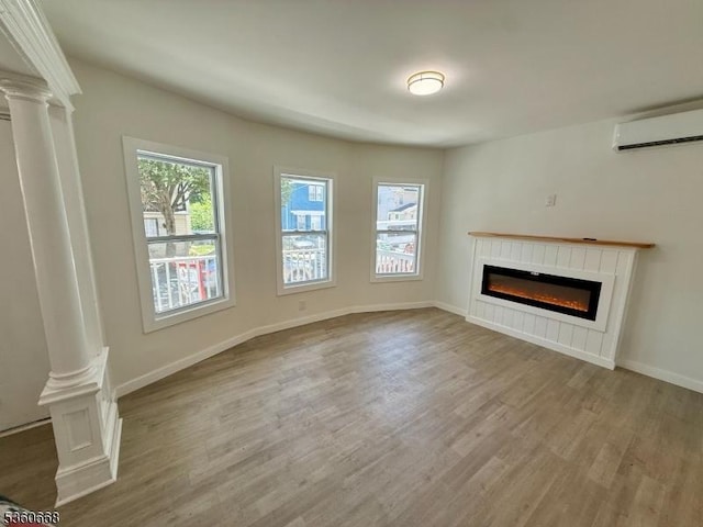 67 Mead St, Newark City, NJ 07106 - unfurnished living room with ornate columns, a wall mounted air conditioner, wood finished floors, a glass covered fireplace, and baseboards