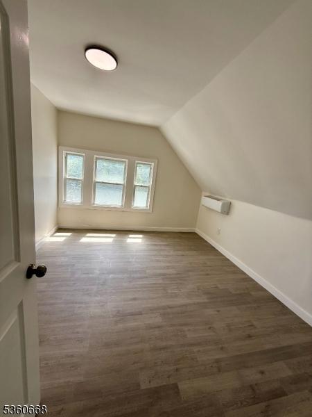 67 Mead St, Newark City, NJ 07106 - additional living space featuring wood finished floors, lofted ceiling, baseboards, and a wall mounted AC