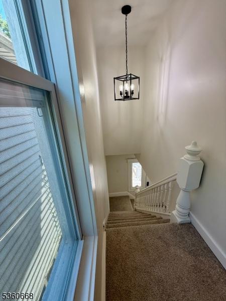 67 Mead St, Newark City, NJ 07106 - staircase featuring a chandelier, baseboards, and carpet floors