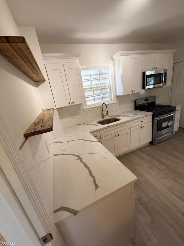 67 Mead St, Newark City, NJ 07106 - kitchen featuring appliances with stainless steel finishes, a sink, white cabinets, and light stone countertops