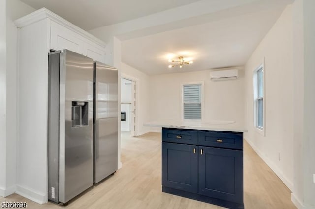 67 Mead St, Newark City, NJ 07106 - kitchen featuring stainless steel fridge with ice dispenser, a wall mounted air conditioner, blue cabinetry, light countertops, and white cabinetry