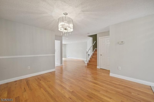 1503 Bayley Ct, Bridgewater Twp, NJ 08807 - empty room featuring a chandelier, stairway, light wood finished floors, and baseboards