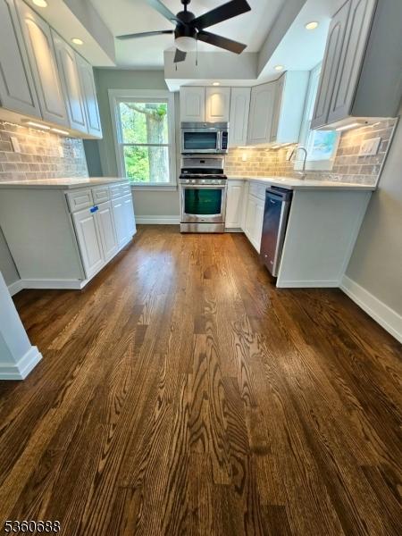 36 Webster Ave, Summit City, NJ 07901 - kitchen with appliances with stainless steel finishes, baseboards, light countertops, dark wood-style flooring, and tasteful backsplash