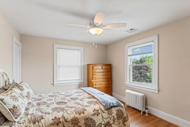 421 Lake Ave, Lyndhurst Twp, NJ 07071 - bedroom with radiator heating unit, wood finished floors, baseboards, and ceiling fan