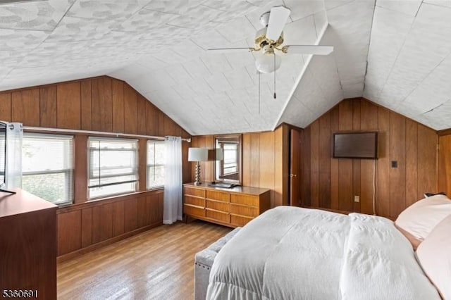 421 Lake Ave, Lyndhurst Twp, NJ 07071 - bedroom featuring light wood-style floors, vaulted ceiling, wood walls, and ceiling fan