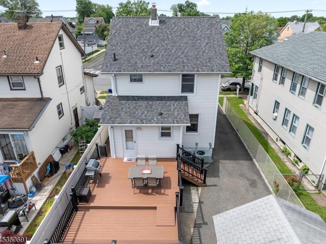 421 Lake Ave, Lyndhurst Twp, NJ 07071 - back of property with outdoor dining space, roof with shingles, a chimney, a fenced backyard, and a residential view