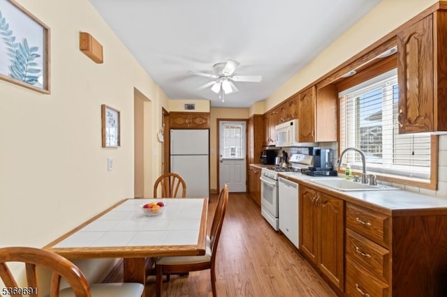 421 Lake Ave, Lyndhurst Twp, NJ 07071 - kitchen featuring white appliances, a sink, ceiling fan, brown cabinetry, and light wood-type flooring