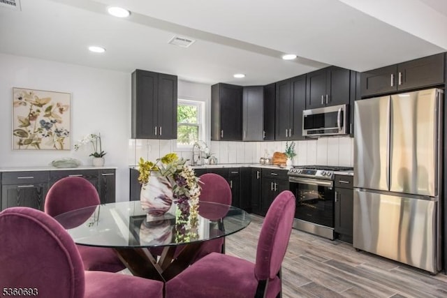 35 Ellis Ave, Irvington Twp, NJ 07111 - kitchen featuring stainless steel appliances, light wood-style flooring, dark cabinetry, recessed lighting, and light countertops