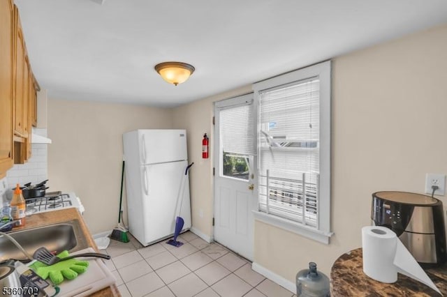 314 Fitzpatrick St, Hillside Twp, NJ 07205 - kitchen with freestanding refrigerator, range hood, tasteful backsplash, baseboards, and light tile patterned floors