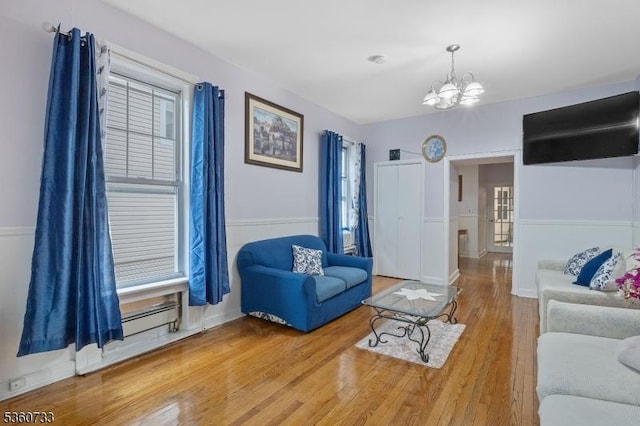 548 Jefferson Ave, Elizabeth City, NJ 07201 - living area featuring wood finished floors, a chandelier, healthy amount of natural light, and a baseboard radiator