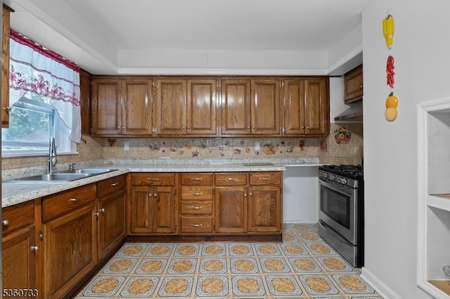 548 Jefferson Ave, Elizabeth City, NJ 07201 - kitchen with gas stove, a sink, light countertops, brown cabinets, and decorative backsplash