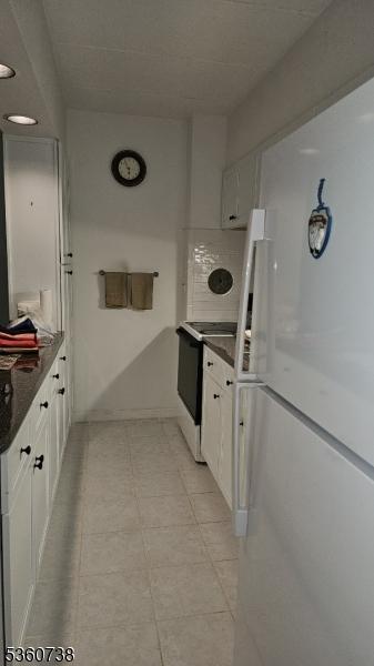 255 Tucker Ave Unit 239, Union Twp, NJ 07083 - kitchen featuring freestanding refrigerator, dark countertops, range with electric stovetop, and white cabinets