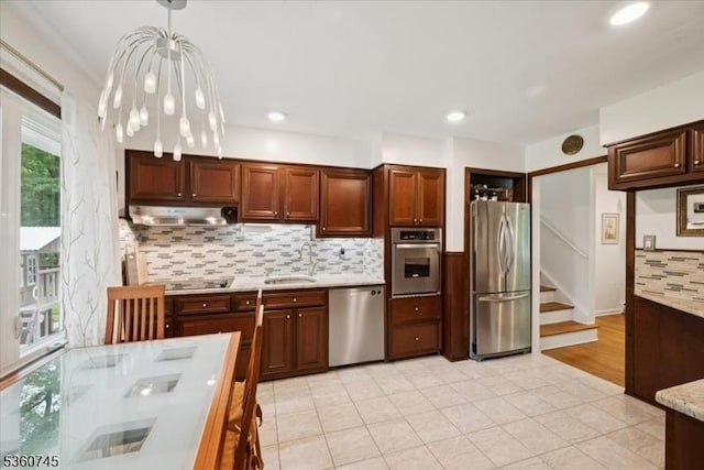42 Wildwood Ter, Watchung Boro, NJ 07069 - kitchen featuring stainless steel appliances, decorative backsplash, under cabinet range hood, light tile patterned floors, and hanging light fixtures