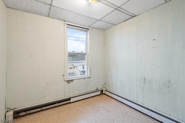 30-32 Geneva St, Elizabeth City, NJ 07206 - spare room featuring a drop ceiling, a baseboard heating unit, tile patterned floors, and wood walls