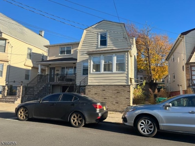 118 Maple St, Kearny Town, NJ 07032 - view of front facade with brick siding, stairs, and a gambrel roof