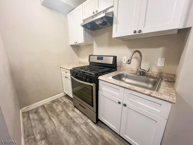 118 Maple St, Kearny Town, NJ 07032 - kitchen with stainless steel range with gas stovetop, under cabinet range hood, a sink, white cabinetry, and light wood finished floors