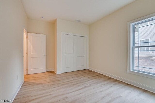 92 Hancock Rd, Piscataway Twp, NJ 08854 - unfurnished bedroom featuring light wood-style floors, multiple windows, and baseboards