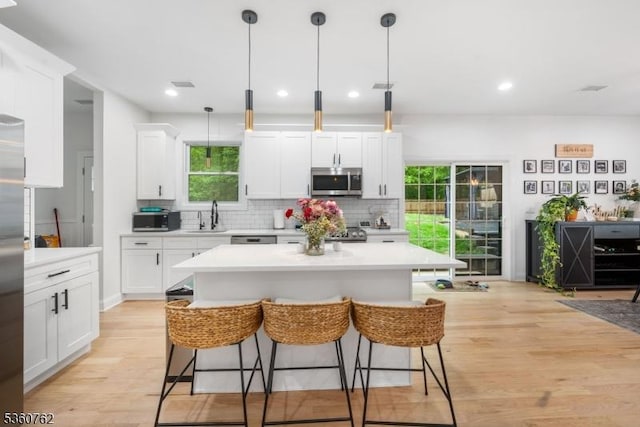 29 Tennis Rd, Jefferson Twp, NJ 07849 - kitchen featuring appliances with stainless steel finishes, a sink, a kitchen breakfast bar, backsplash, and light countertops
