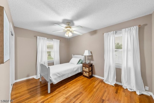 17 4th St, South River Boro, NJ 08882 - bedroom with light wood-type flooring, a textured ceiling, baseboards, and a ceiling fan