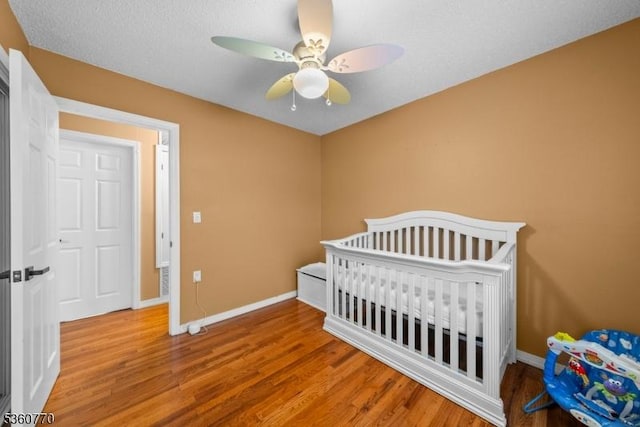 17 4th St, South River Boro, NJ 08882 - bedroom with wood finished floors, baseboards, a crib, and ceiling fan