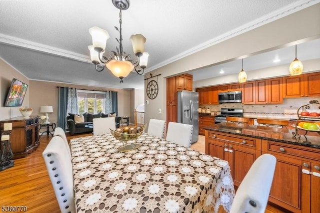 17 4th St, South River Boro, NJ 08882 - dining room with a chandelier, light wood-style flooring, and ornamental molding
