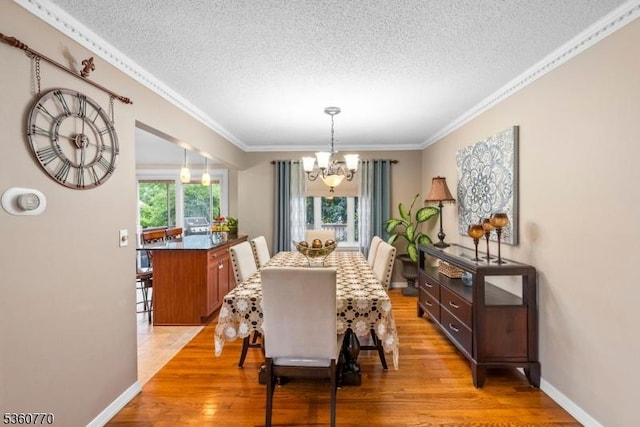 17 4th St, South River Boro, NJ 08882 - dining room featuring a textured ceiling, a chandelier, crown molding, light wood-type flooring, and baseboards