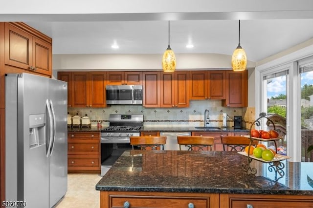 17 4th St, South River Boro, NJ 08882 - kitchen featuring appliances with stainless steel finishes, a sink, decorative backsplash, brown cabinetry, and pendant lighting
