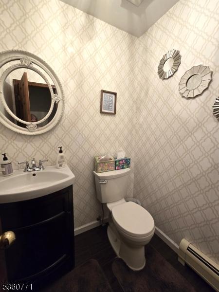14 Constitution Ave, Roxbury Twp, NJ 07876 - half bath featuring a baseboard heating unit, baseboards, toilet, and vanity