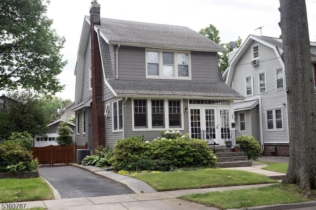 137 Oak Ridge Ave, Nutley Twp, NJ 07110 - view of front of property featuring french doors, roof with shingles, a chimney, and a front yard