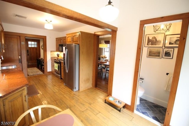 137 Oak Ridge Ave, Nutley Twp, NJ 07110 - kitchen featuring stainless steel appliances, a sink, brown cabinetry, baseboards, and light wood-type flooring
