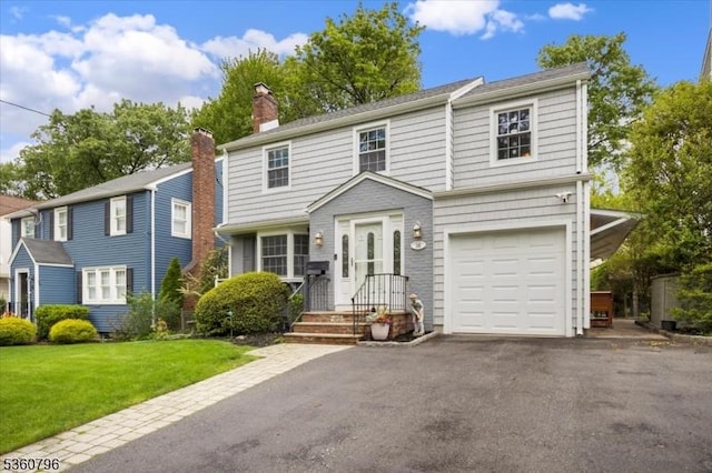 30 Newman Ave, Verona Twp, NJ 07044 - view of front facade with a chimney, asphalt driveway, a front lawn, and an attached garage