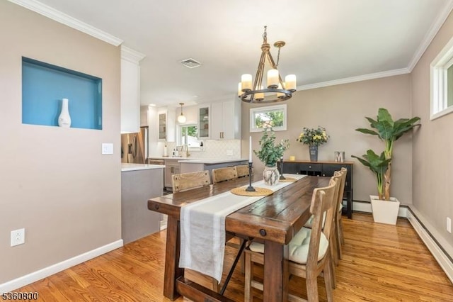 31 Woodside Ave, Cranford Twp, NJ 07016 - dining room featuring a baseboard radiator, a chandelier, light wood-style flooring, and crown molding