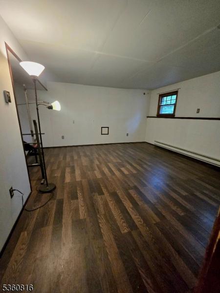 103 Mountain Top Rd, Lebanon Twp, NJ 08826 - empty room with dark wood finished floors and a baseboard heating unit