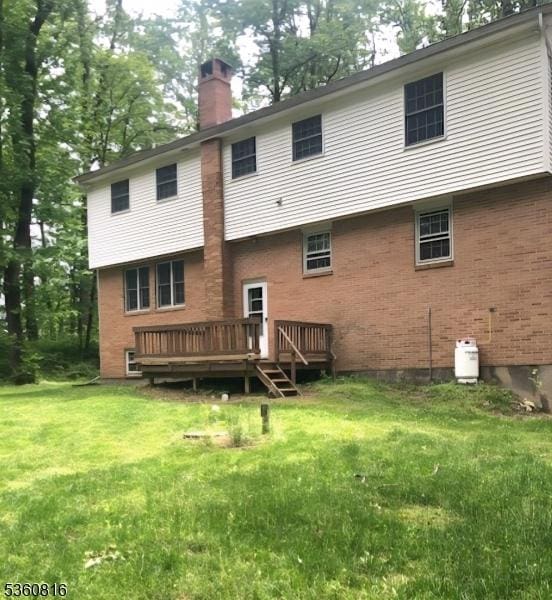 103 Mountain Top Rd, Lebanon Twp, NJ 08826 - back of house with a chimney, a deck, brick siding, and a lawn