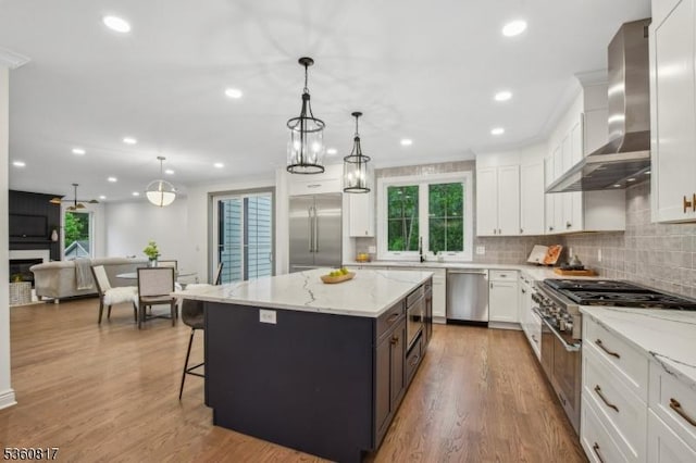 48 Lewis Ave, Summit City, NJ 07901 - kitchen featuring wall chimney range hood, built in appliances, white cabinetry, wood finished floors, and tasteful backsplash