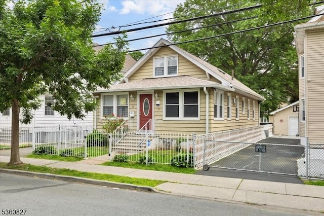 5 Ward St, Clifton City, NJ 07011 - view of front facade with a gate, a fenced front yard, a detached garage, and roof with shingles